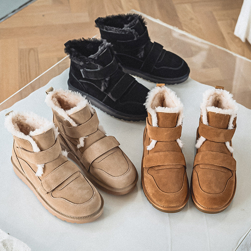 Three color options of fleece-lined suede winter boots with velcro straps, in tan, black, and cognac, displayed together on a glass surface.