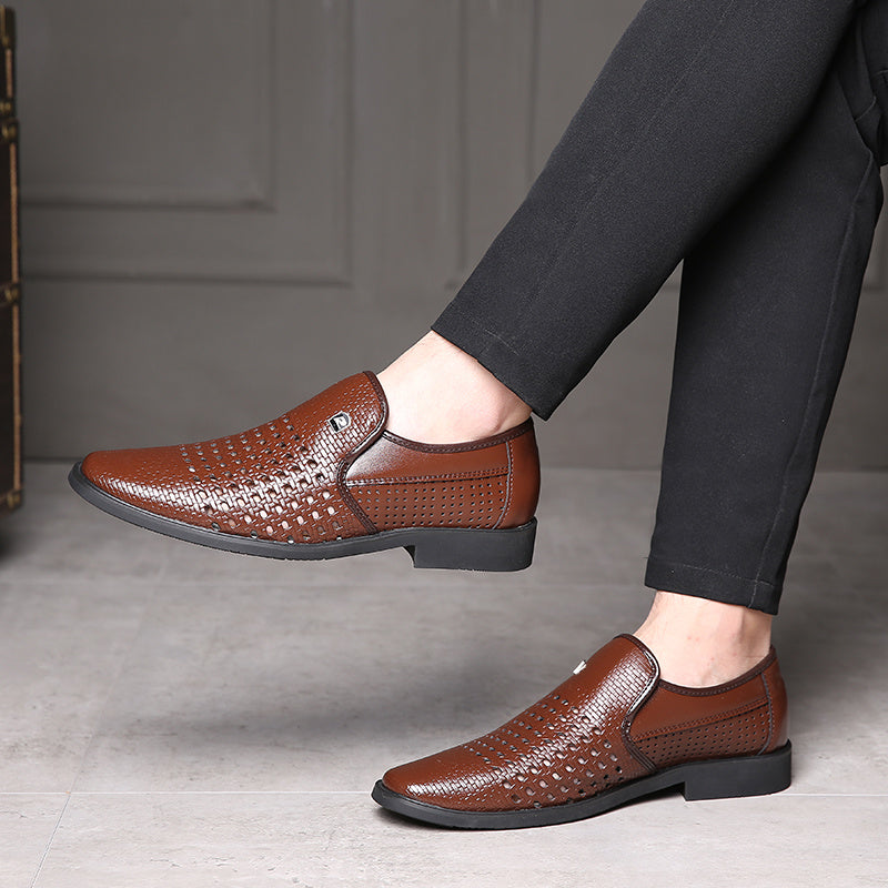 Brown woven calfskin leather loafers with breathable perforated upper and flexible black sole, worn with black trousers in a modern indoor setting.