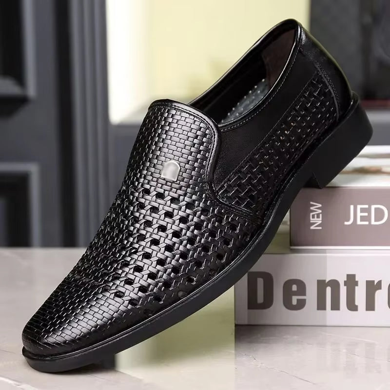 Black woven calfskin leather loafer with breathable perforated upper, slip-on design, and flexible black outsole, displayed on stacked books.