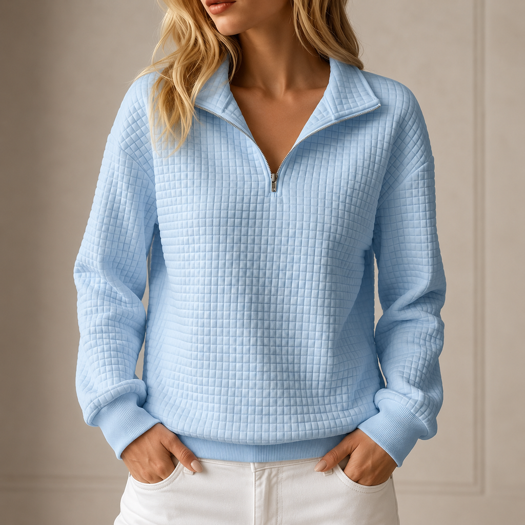 Light blue grid-quilted half-zip sweatshirt worn by a female model