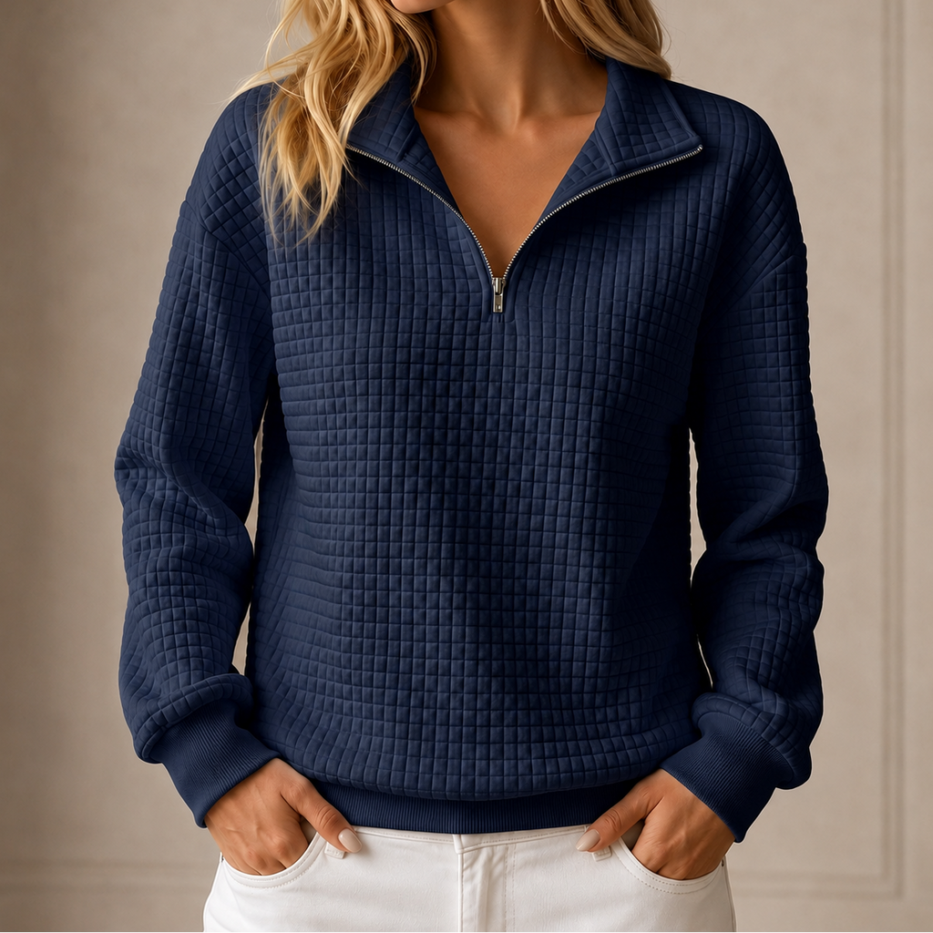 Grid-quilted half-zip sweatshirt worn by a female model in navy, front view