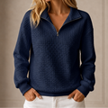Grid-quilted half-zip sweatshirt worn by a female model in navy, front view