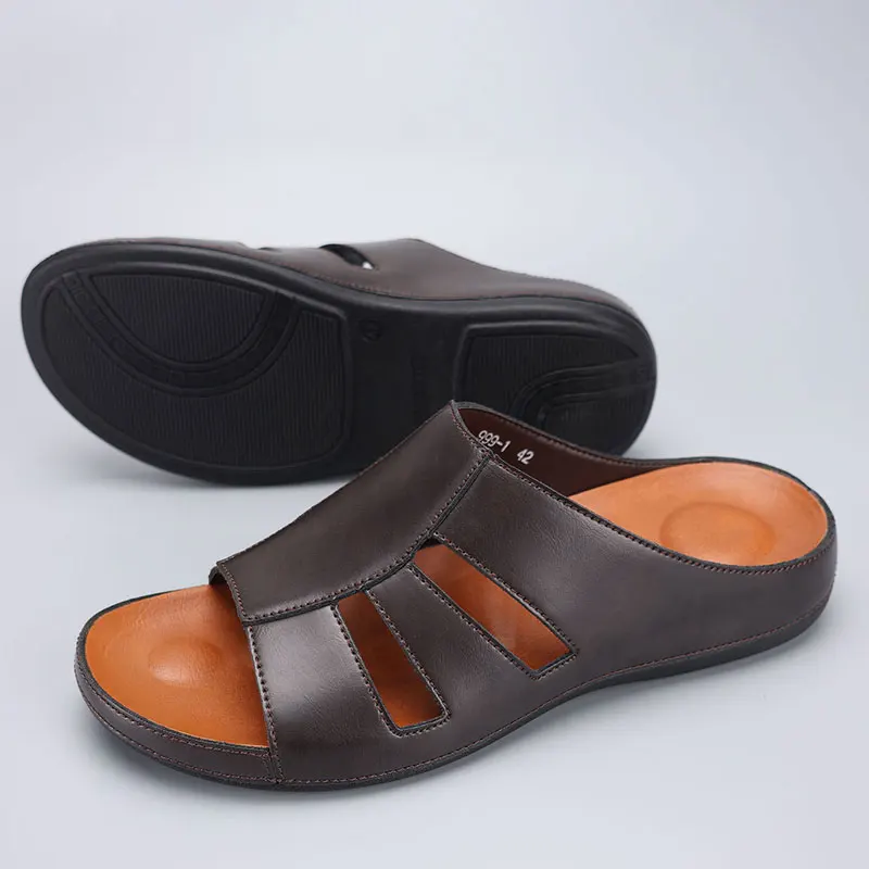 Pair of chocolate brown leather slip-on sandals with one shoe turned over to display the textured rubber outsole.