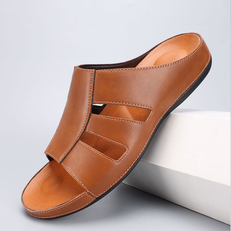 Tan leather slip-on sandal with cutout strap detailing, angled on a white display block to show the tonal footbed.