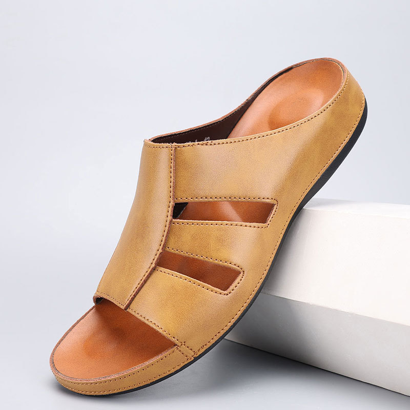 Light tan leather slip-on sandal with cutout strap detailing, angled on a white display block against a plain backdrop.