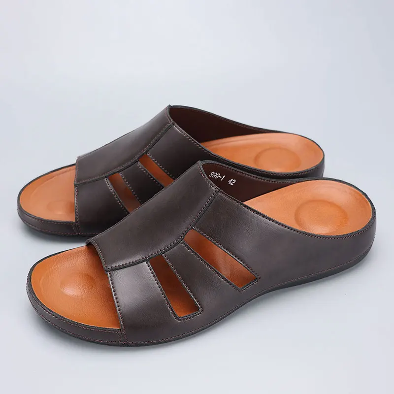 Pair of chocolate brown leather slip-on sandals resting flat side by side, showing the cutout straps and orange footbeds from above.