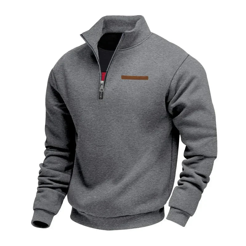 Dark gray half-zip fleece sweatshirt with a stand collar, ribbed cuffs, and chest accent detail on a white background.