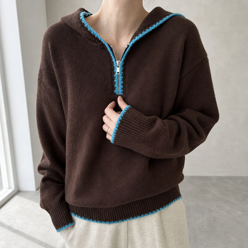 Brown hooded knit half-zip pullover worn by a female model adjusting the zipper