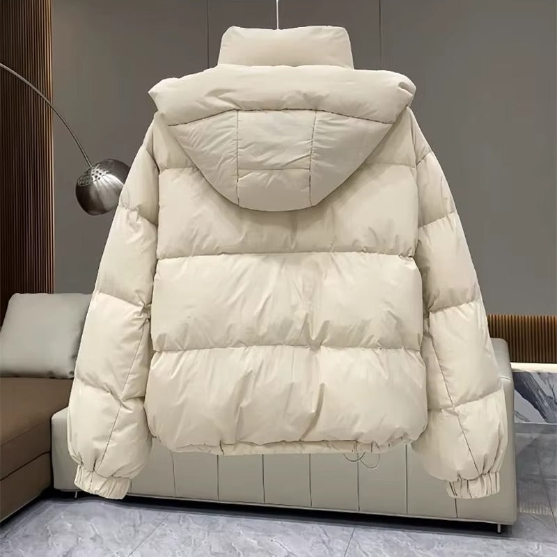 Cream hooded puffer jacket with quilted insulation, high funnel neck, and relaxed fit, shown from the back.