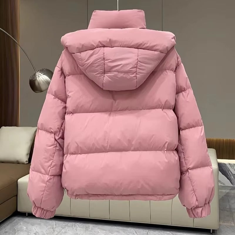 Dusty pink quilted puffer jacket with a high funnel neck, attached hood, and relaxed fit, shown from the back.