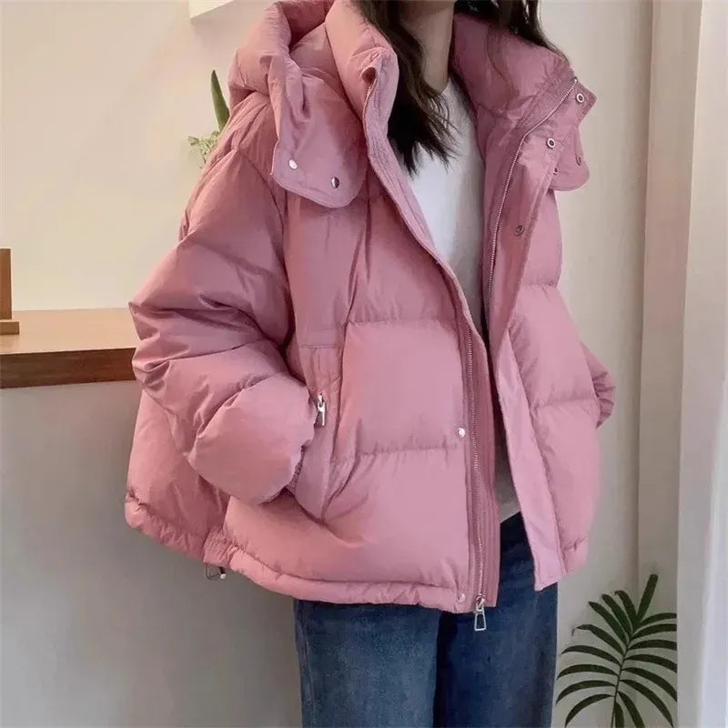 Dusty pink hooded puffer jacket with a high funnel neck, quilted insulation, and a relaxed fit for easy layering.