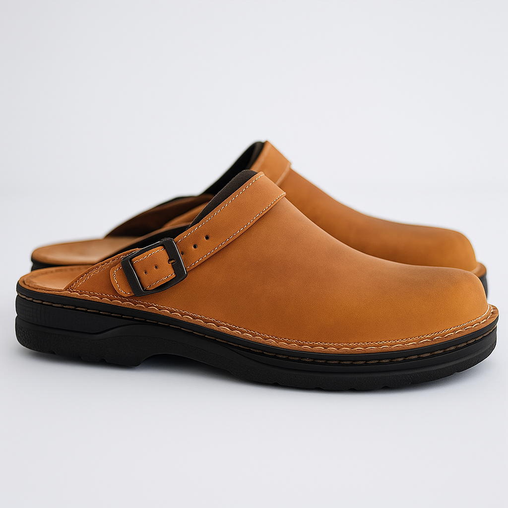 Pair of tan leather slip-on clogs featuring adjustable buckle straps, cushioned footbeds, and durable black outsoles on a white background.