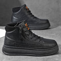 Pair of black leather Hudson high-top sneakers with side zipper, orange pull tab, and chunky platform sole