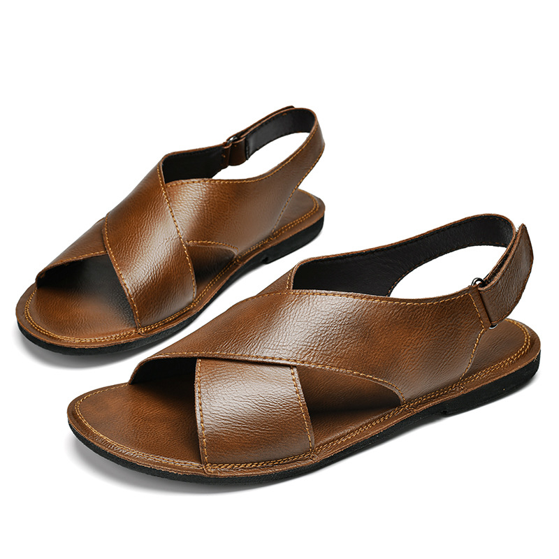 Pair of brown leather cross-wrap sandals arranged together on a white background, displaying the matching crisscross straps and buckle closures on both shoes.