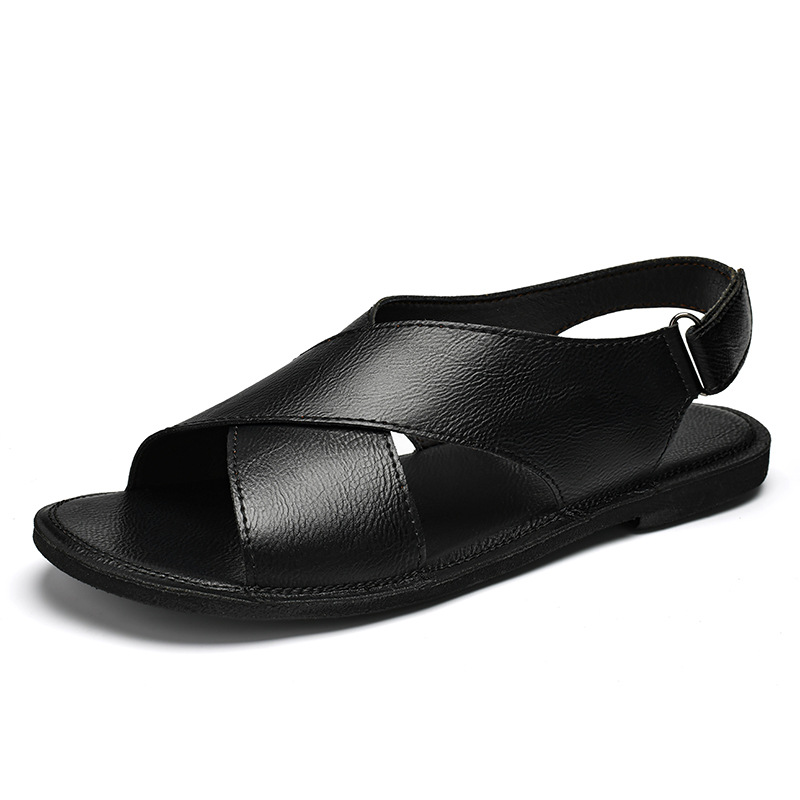 Side profile product shot of a black leather cross-wrap sandal on a plain white background, highlighting the crisscross upper and side buckle strap.