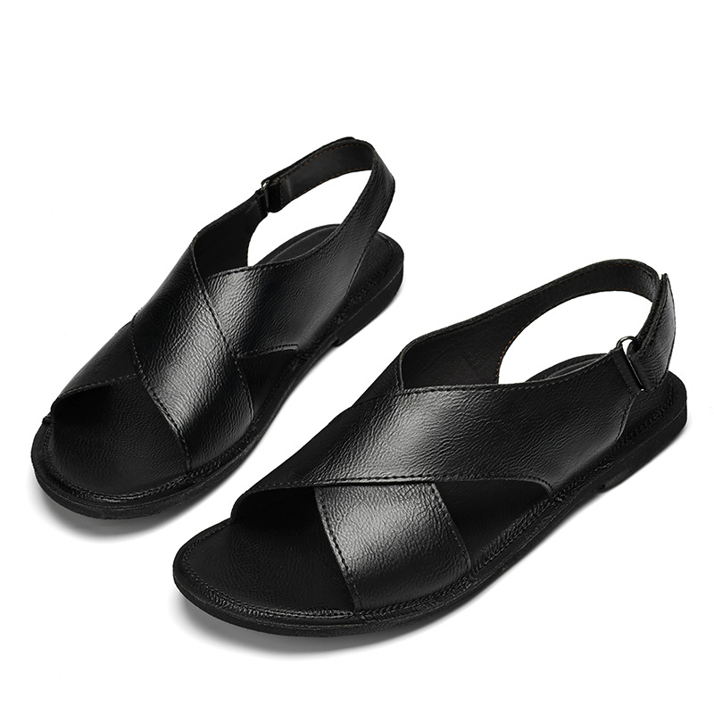 Front-angled view of a pair of black leather cross-wrap sandals on a white background, emphasizing the woven crisscross straps across the foot.