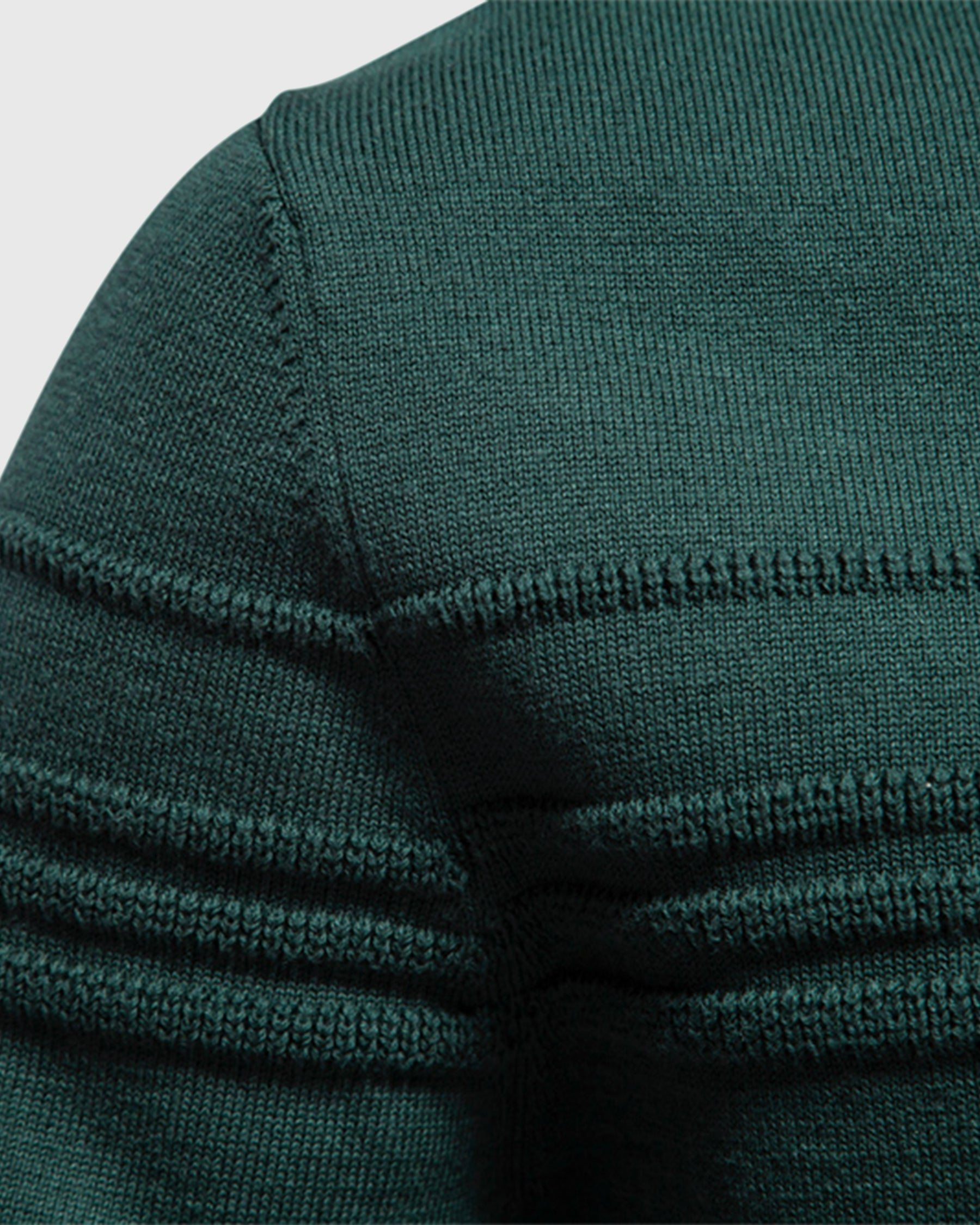 Close-up of forest green ribbed knit sweater shoulder seam detail