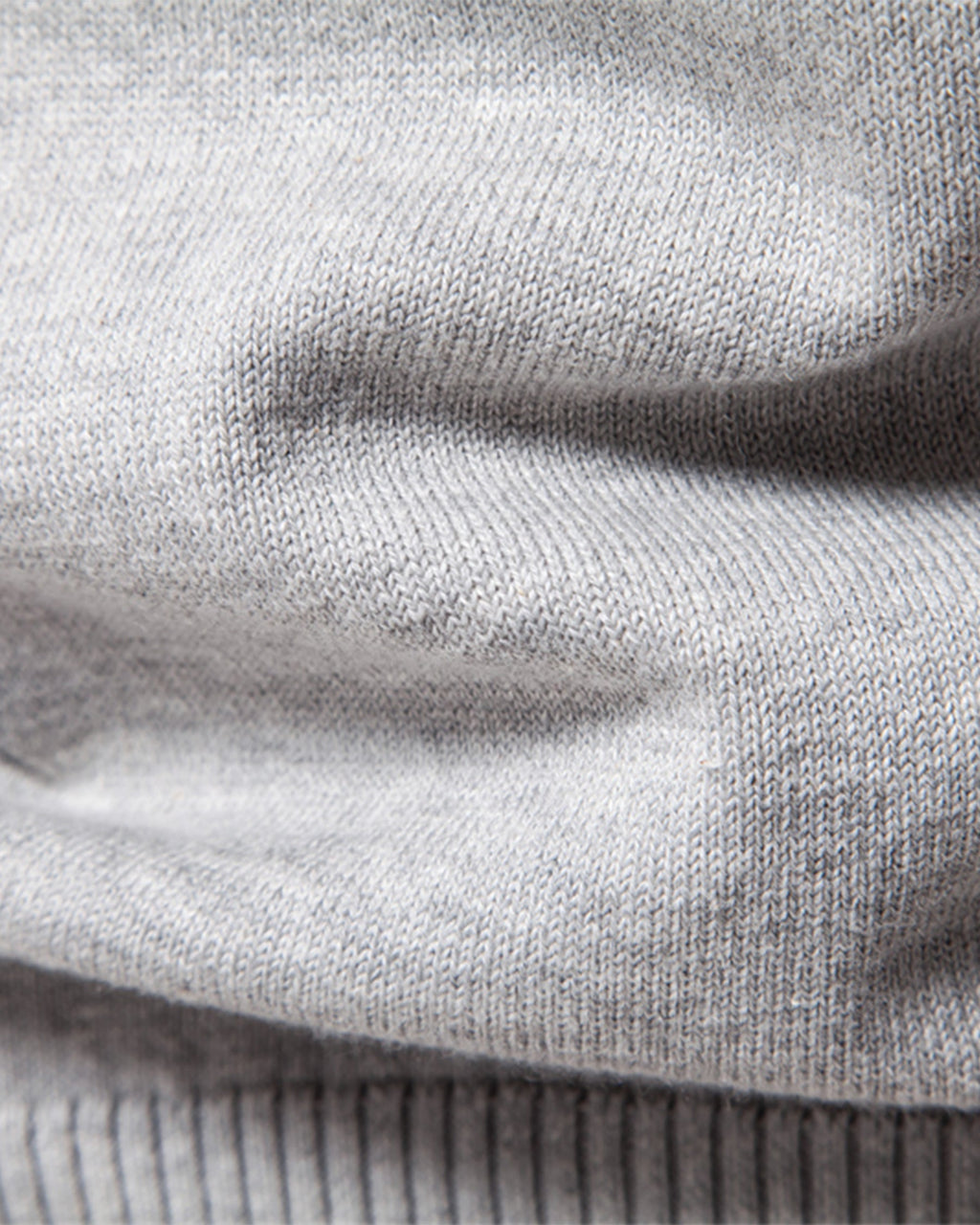 Close-up of light grey knit sweater ribbed texture