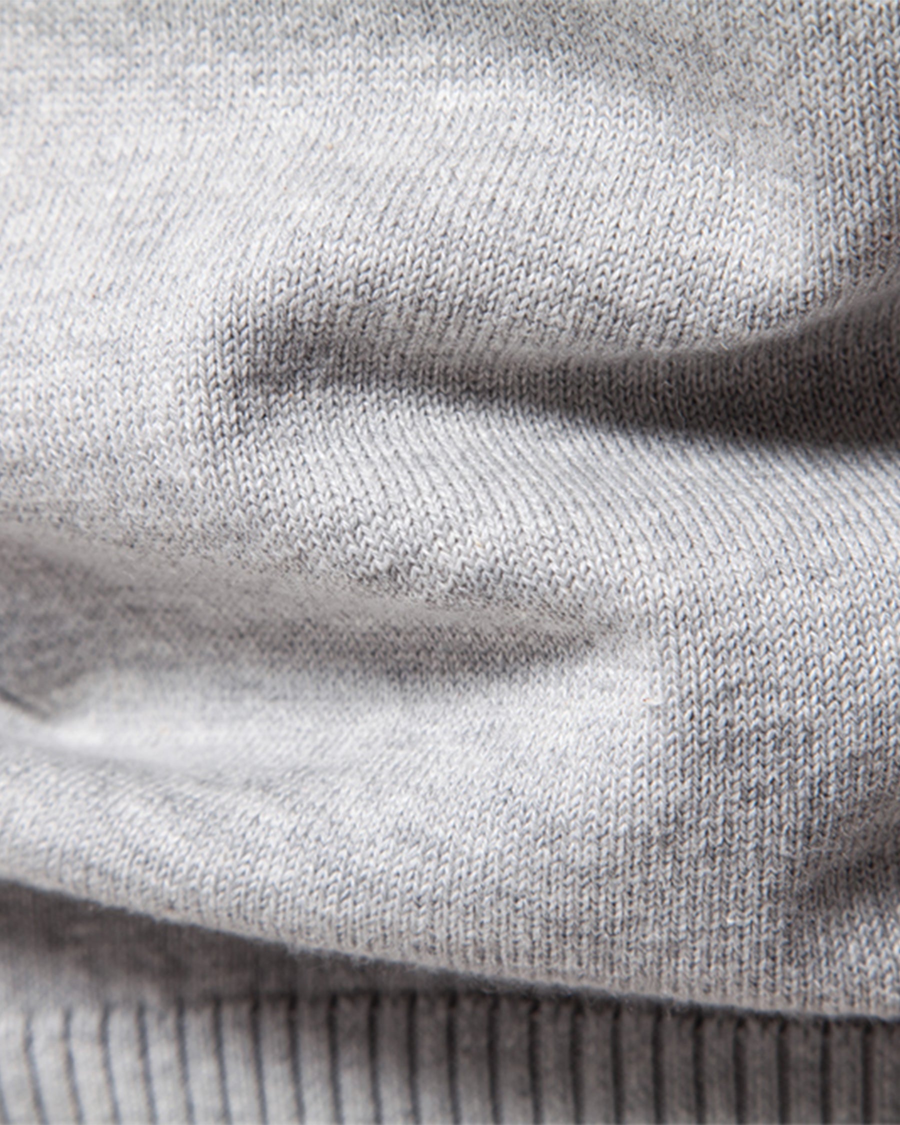 Close-up of light grey knit sweater ribbed texture