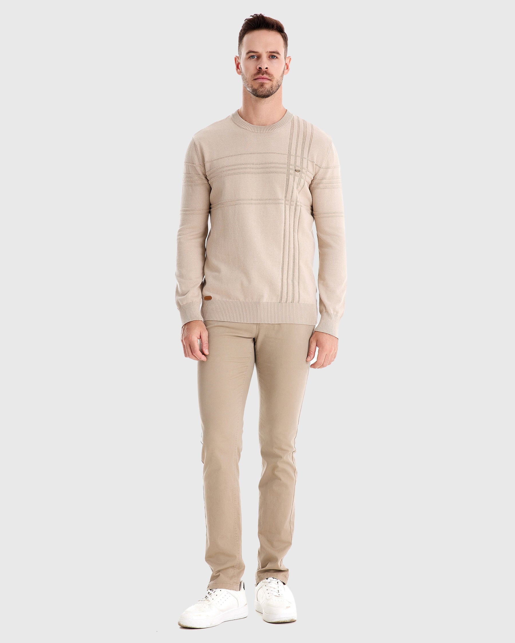 Man wearing beige knit sweater and matching trousers, full-body front view