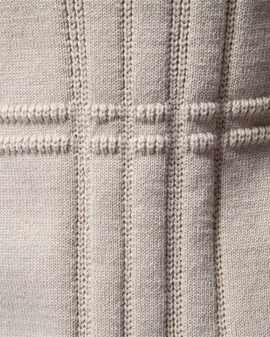 Close-up of beige knit sweater vertical ribbed texture
