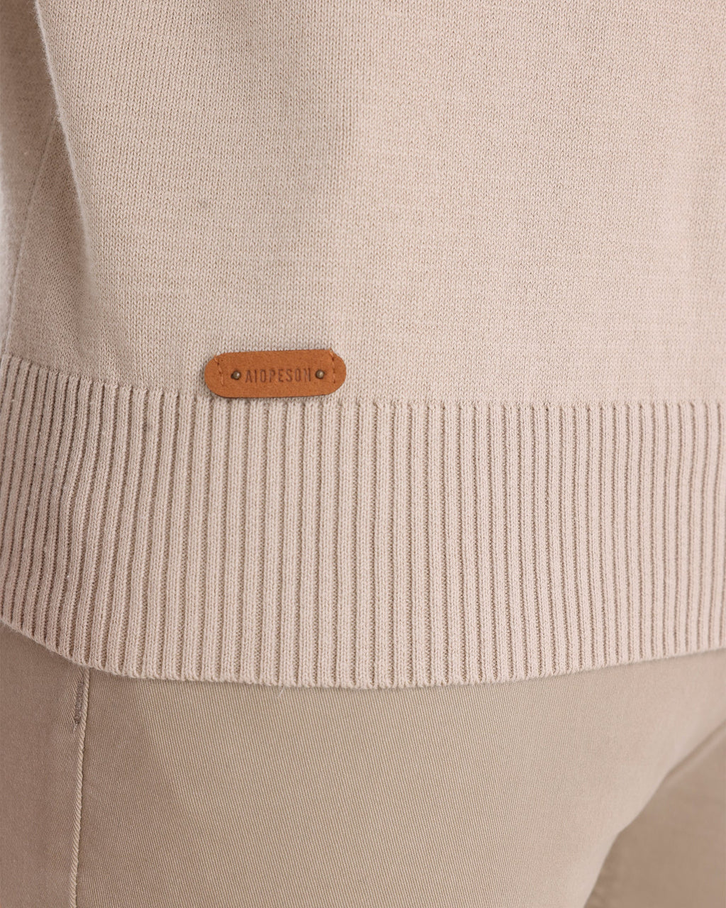 Close-up of beige knit sweater ribbed cuff detail