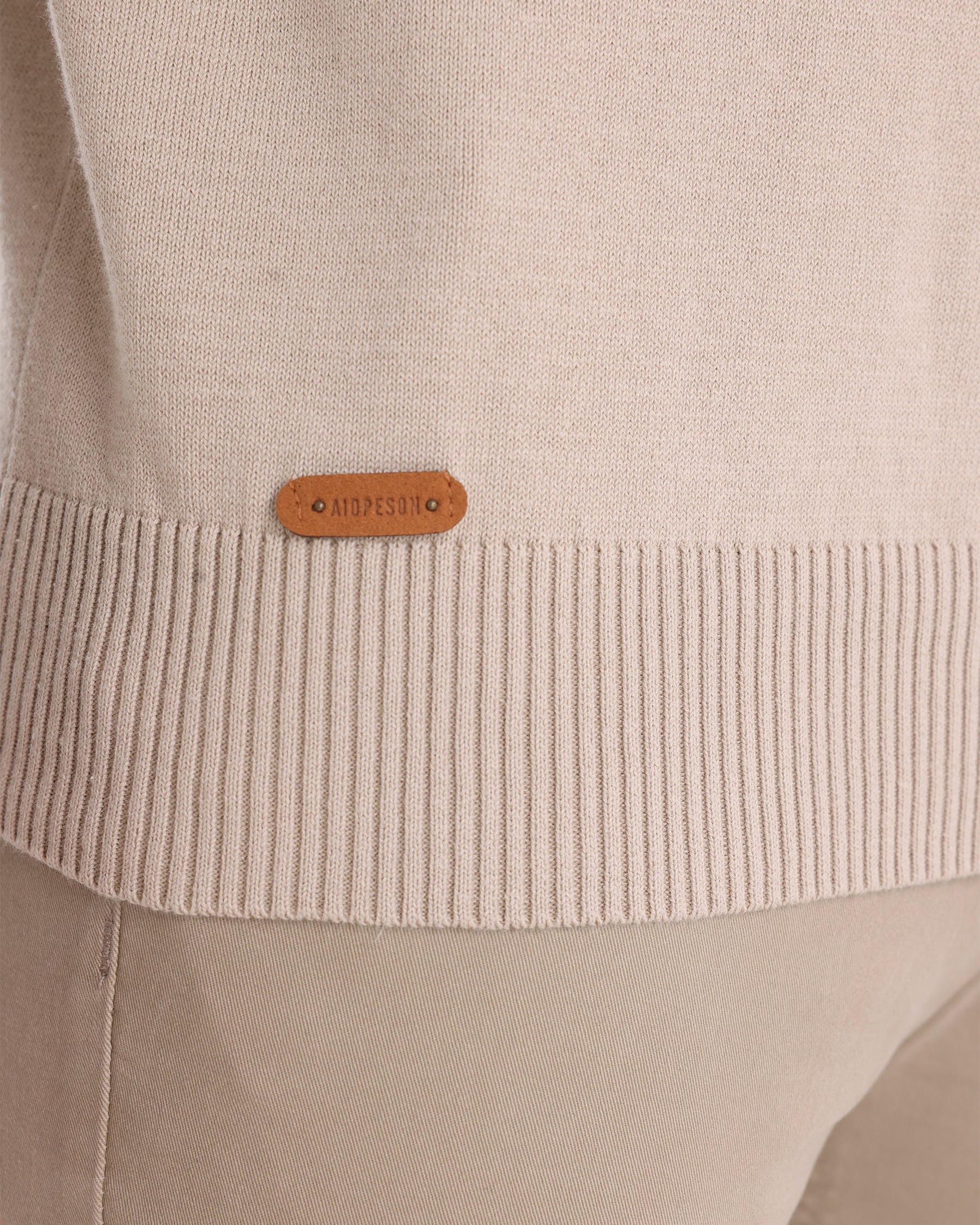 Close-up of beige knit sweater ribbed cuff detail