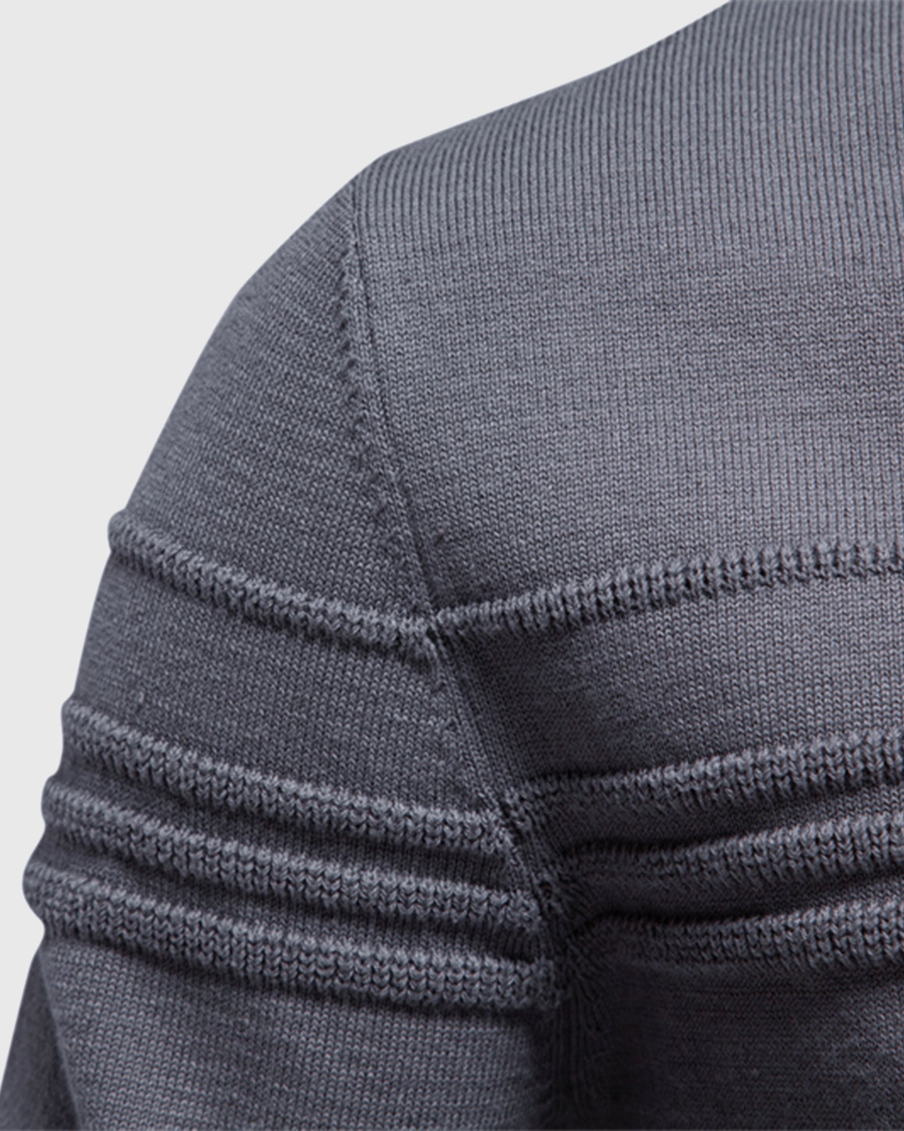 Close-up of the gray crew neck sweater highlighting the textured shoulder knit and ribbed sleeve design.