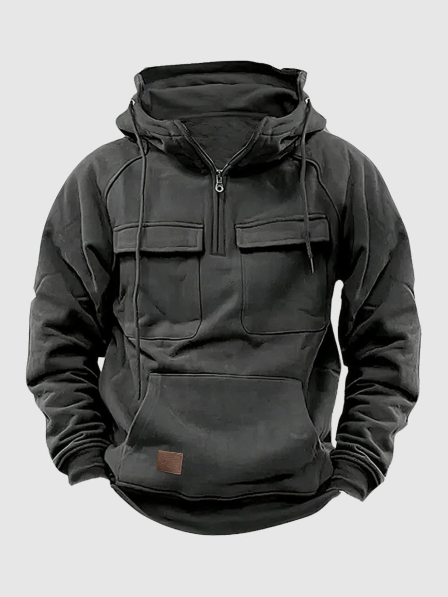 Dark gray tactical pullover hoodie featuring a half-zip stand collar, adjustable hood, dual flap chest pockets, and front kangaroo pocket on a white background.