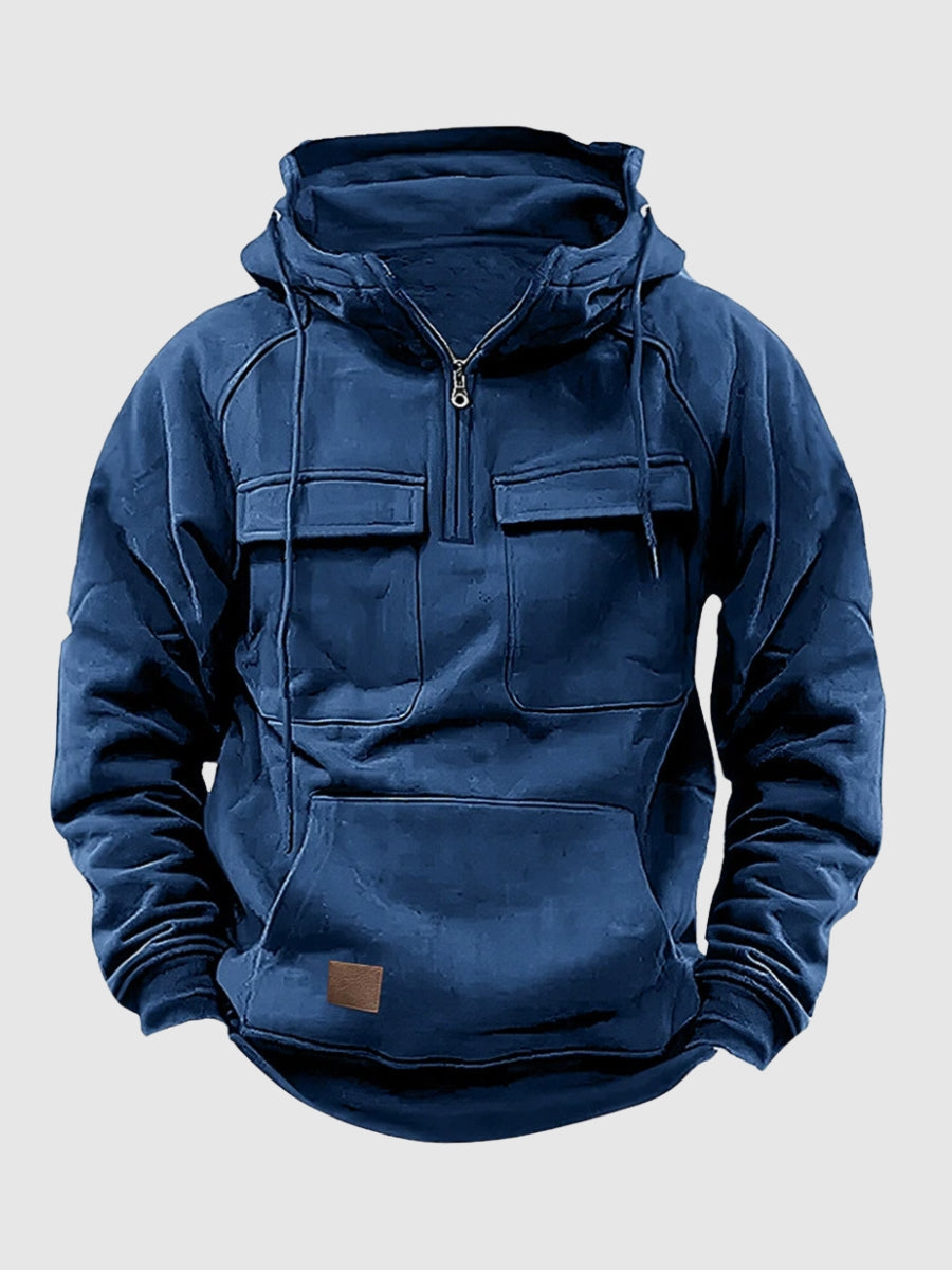 Blue tactical pullover hoodie featuring a half-zip stand collar, adjustable hood, dual flap chest pockets, and kangaroo pocket on a white background.