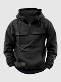 Black tactical pullover hoodie with a half-zip stand collar, adjustable hood, flap chest pockets, and kangaroo pocket displayed on a white background.
