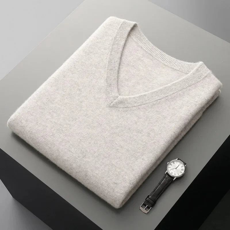 Folded men's cream V-neck knit sweater vest highlighting the soft knit fabric and ribbed neckline.