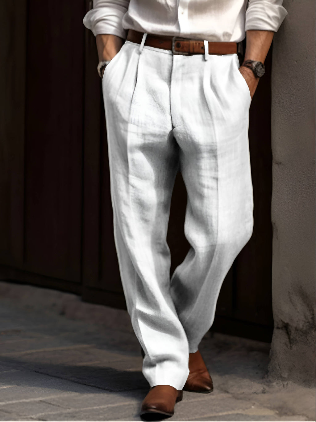 Man wearing light gray linen trousers with a pleated front, straight-leg silhouette, and tailored casual fit.
