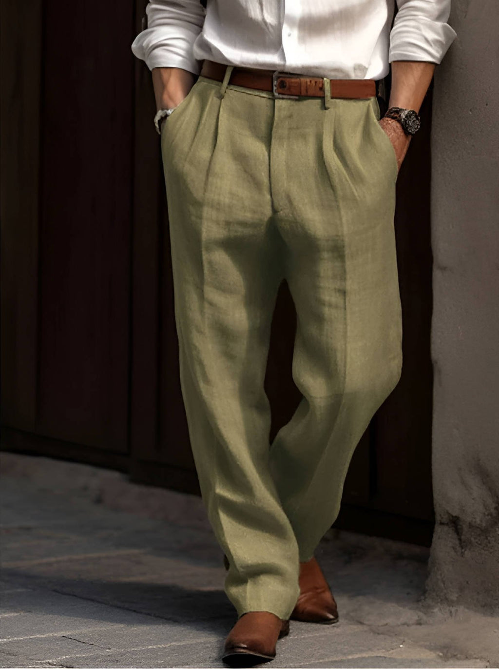 Man wearing olive green linen trousers featuring a relaxed straight-leg fit, pleated front, and breathable lightweight fabric.