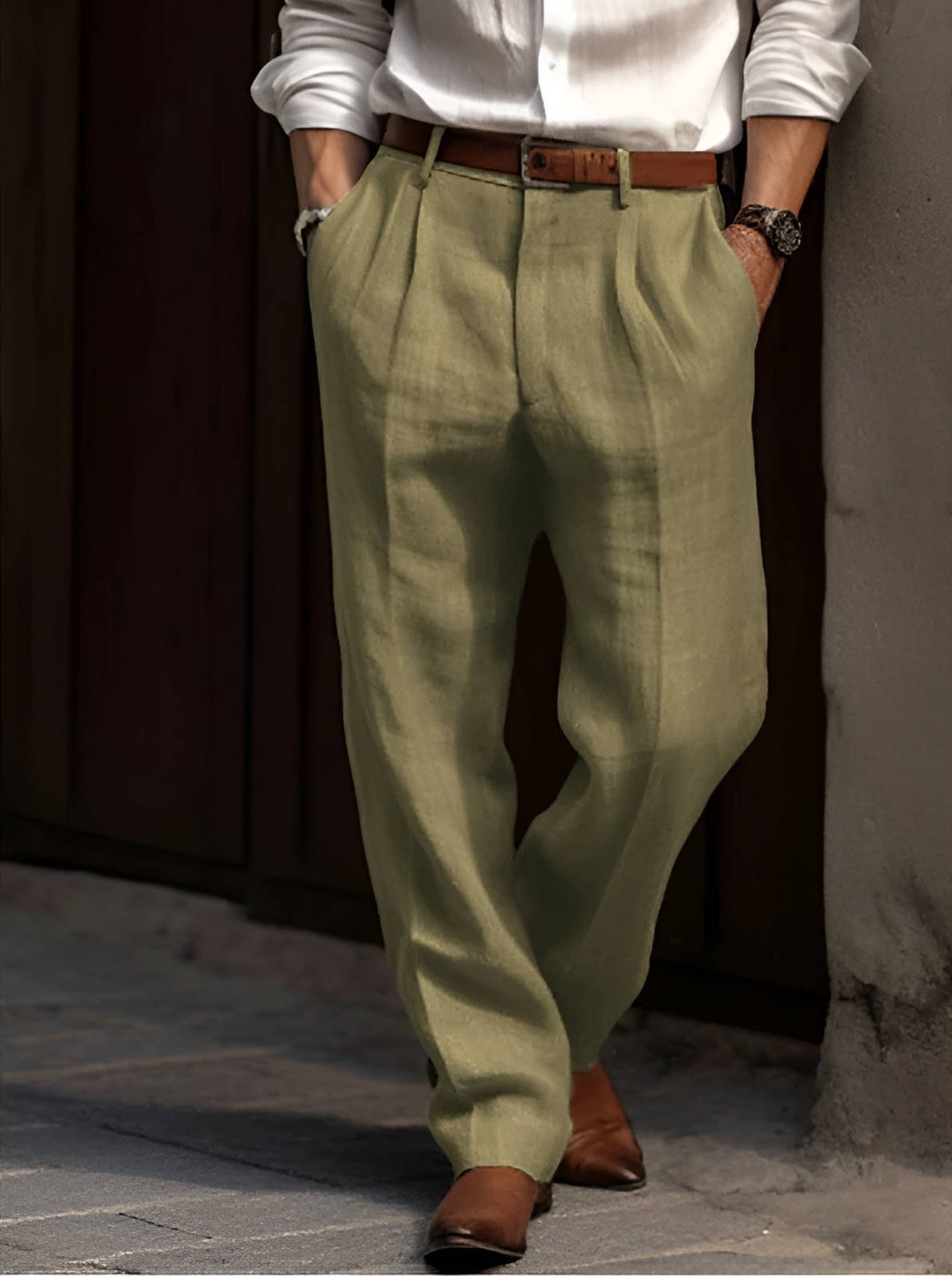Man wearing olive green linen trousers featuring a relaxed straight-leg fit, pleated front, and breathable lightweight fabric.