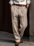 Man wearing beige linen trousers with a relaxed straight-leg fit, pleated front, belt loops, and side pockets.