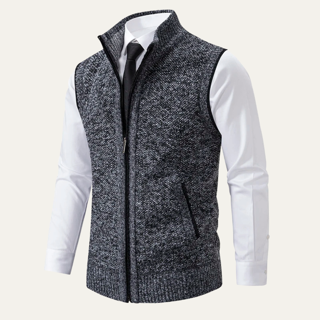 Men's gray marled knit zip-up sweater vest with a stand collar, sleeveless construction, and front zip closure layered over a white dress shirt.