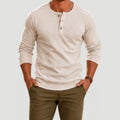 Men's cream long-sleeve Henley sweater featuring a three-button placket, crew neckline, ribbed cuffs, and a textured knit finish.