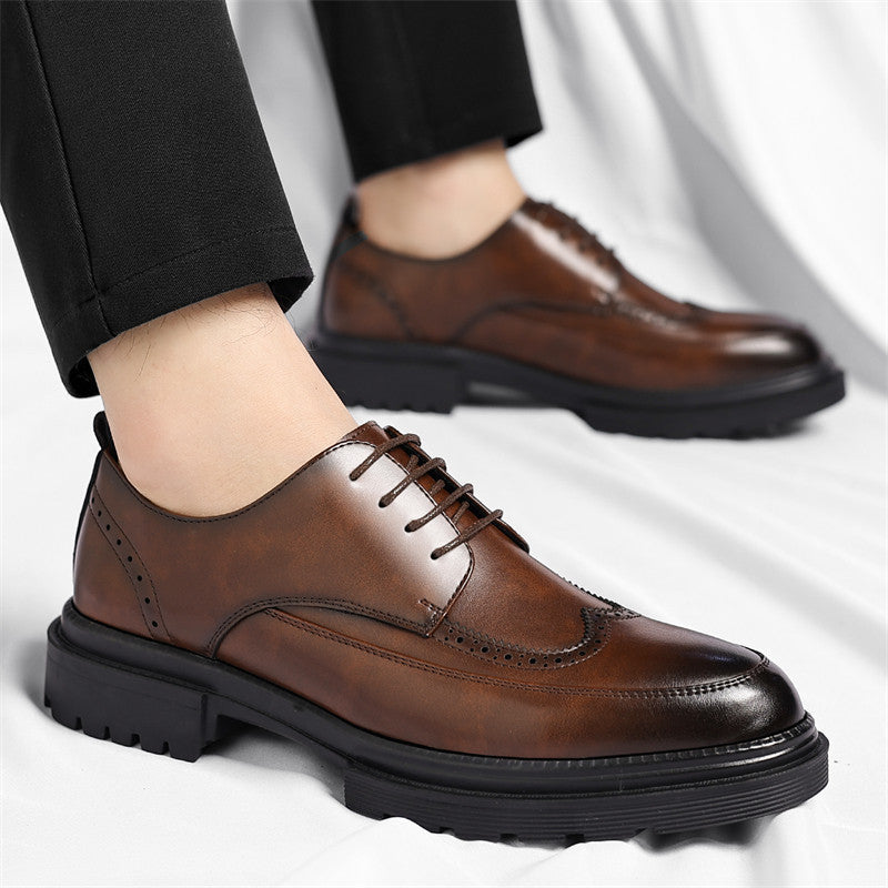 Man wearing brown leather Julian brogue dress shoes with black tailored trousers, standing on a white backdrop