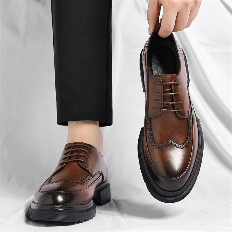 Man in black trousers wearing one brown leather Julian brogue dress shoe while holding the matching shoe by hand