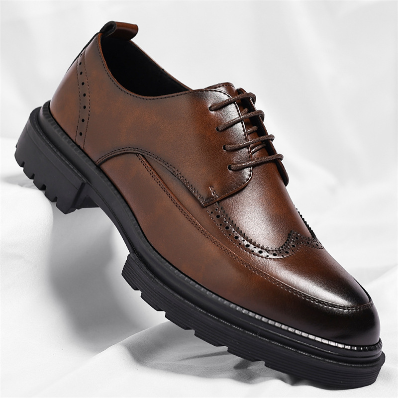 Single brown leather Julian brogue dress shoe with wingtip perforated detailing and chunky black sole, on a white fabric backdrop