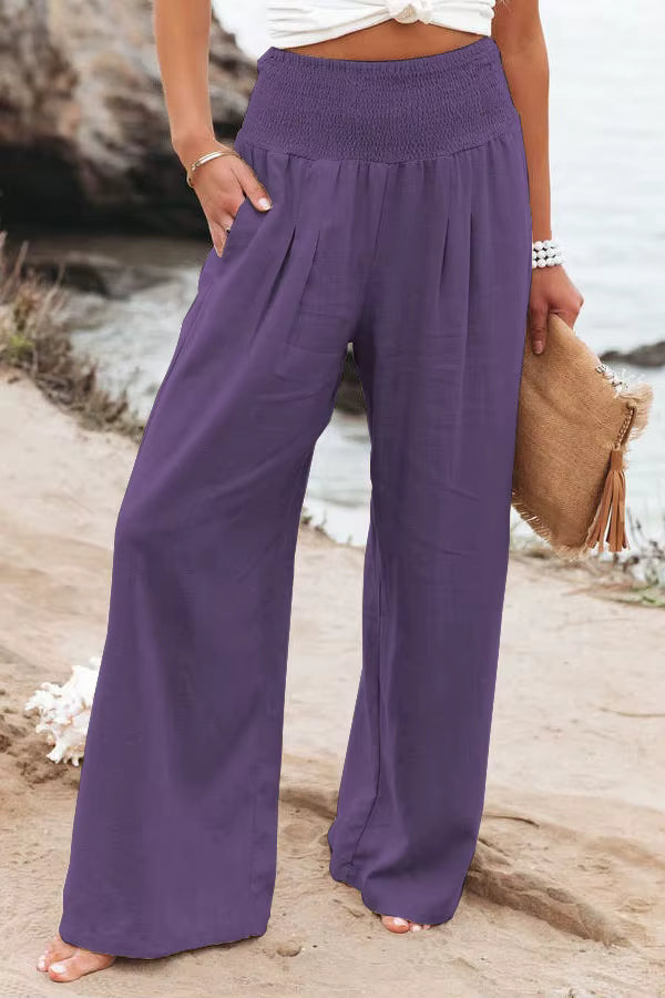 Women's purple wide-leg linen pants featuring a high waist, flowy fit, and breathable fabric.