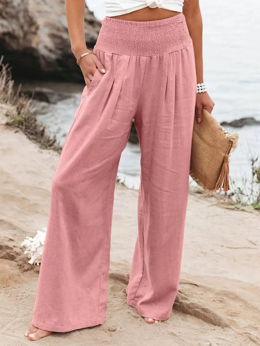 Women's pink high-waisted wide-leg linen pants featuring a relaxed fit and soft breathable fabric.
