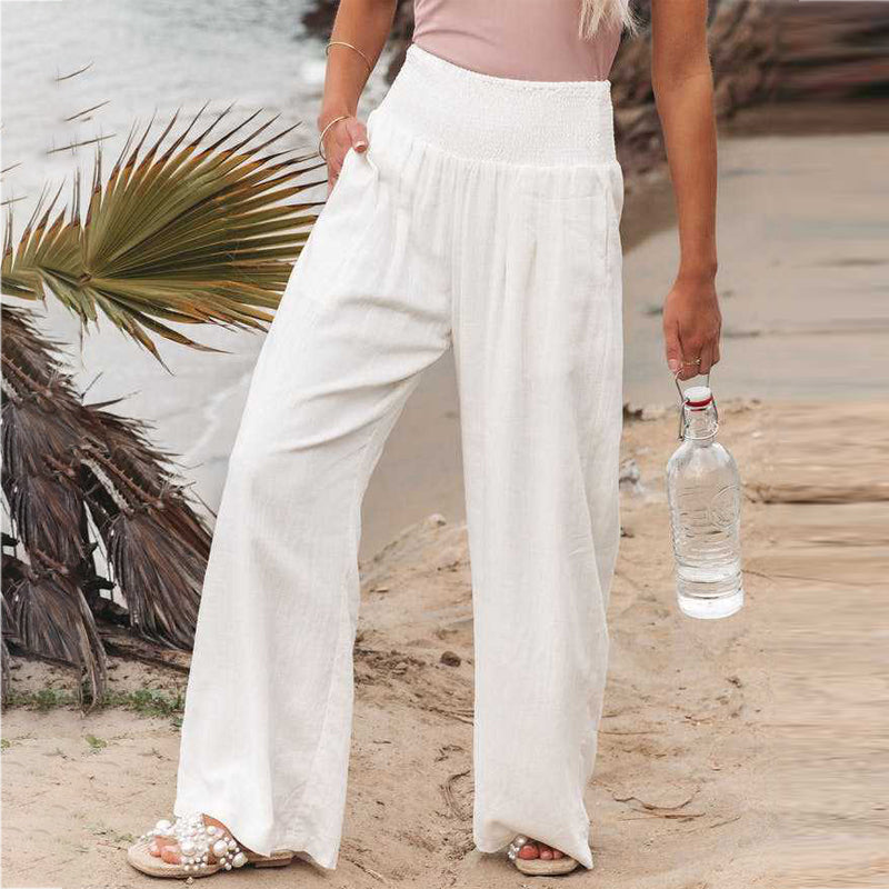 Woman wearing white wide-leg linen pants with a relaxed fit and lightweight breathable fabric.