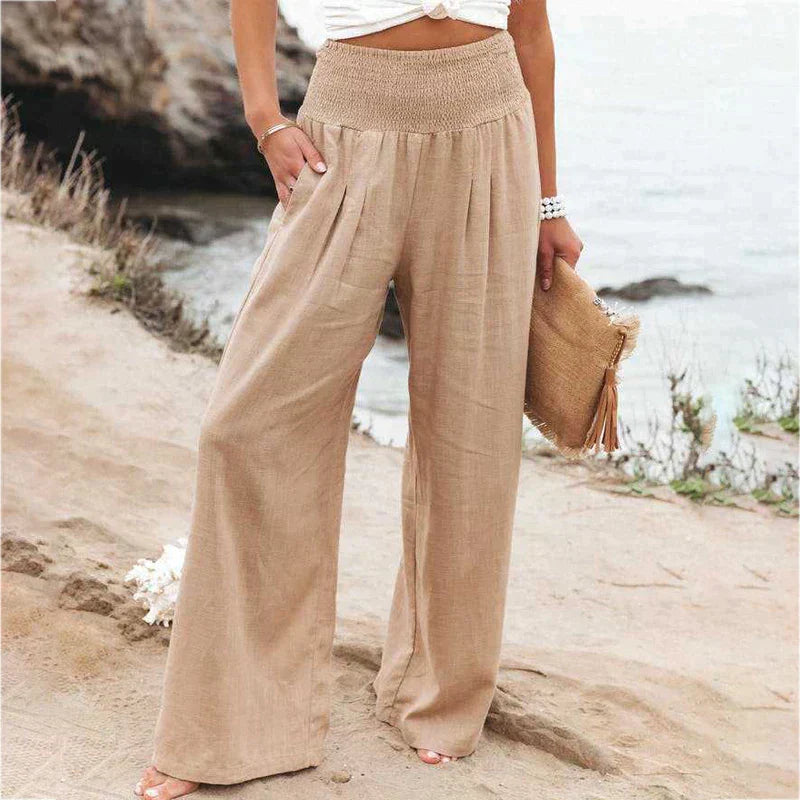 Women's beige high-waisted wide-leg linen pants with a loose, flowy silhouette and side pockets.