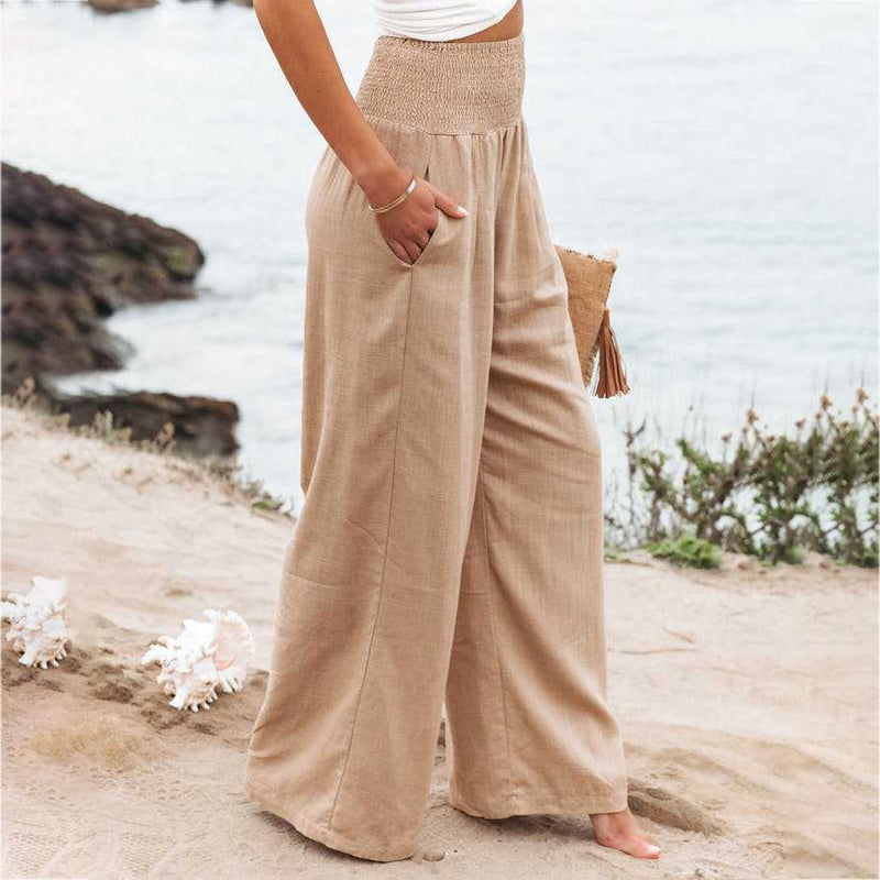 Side view of women's beige linen wide-leg pants featuring a lightweight, flowing design.