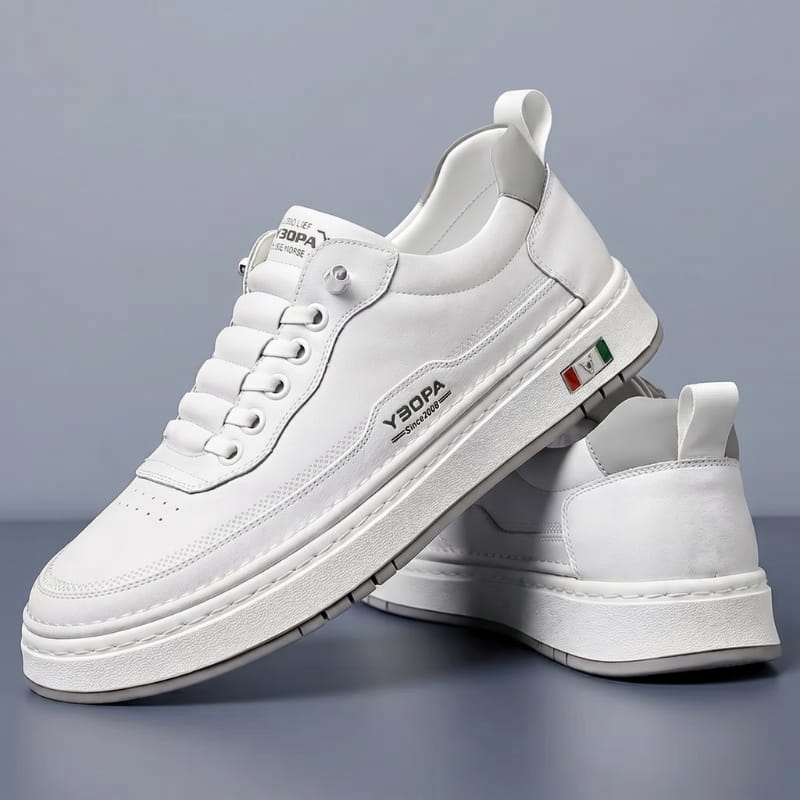 Pair of white leather chunky sneakers stacked at an angle on a gray studio background