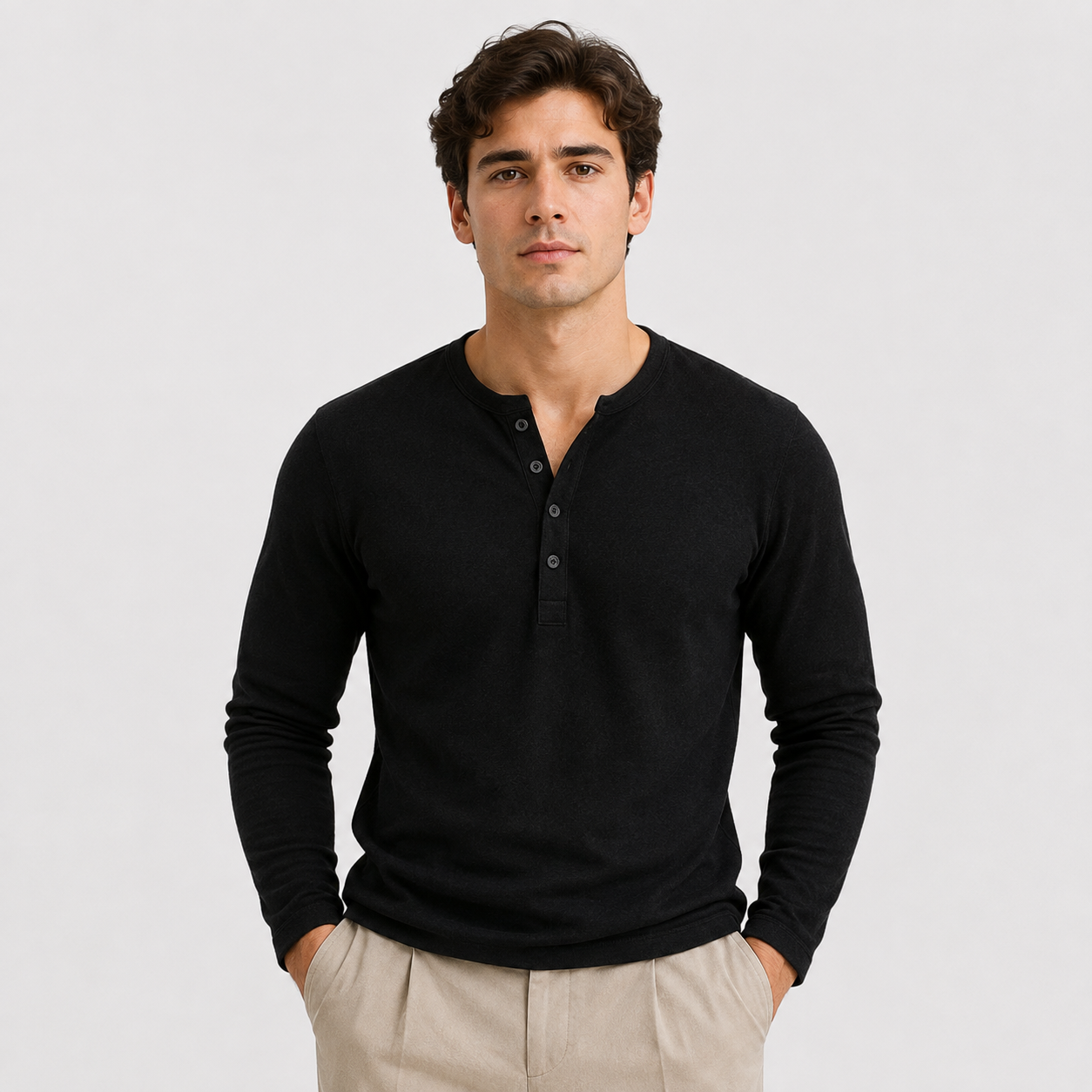 Man wearing a black long-sleeve Henley sweater with a three-button placket, ribbed cuffs, and a classic slim fit.