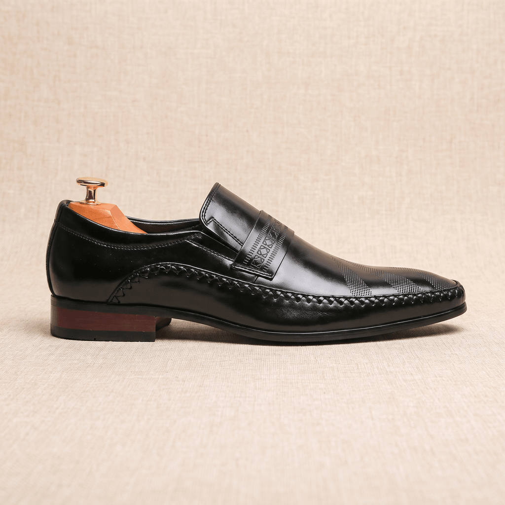 Single black patent leather Leonardo loafer shown in side profile with wooden shoe tree on beige backdrop