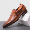 Single brown leather Leonardo loafer with etched band detail, propped against a white block in studio setting